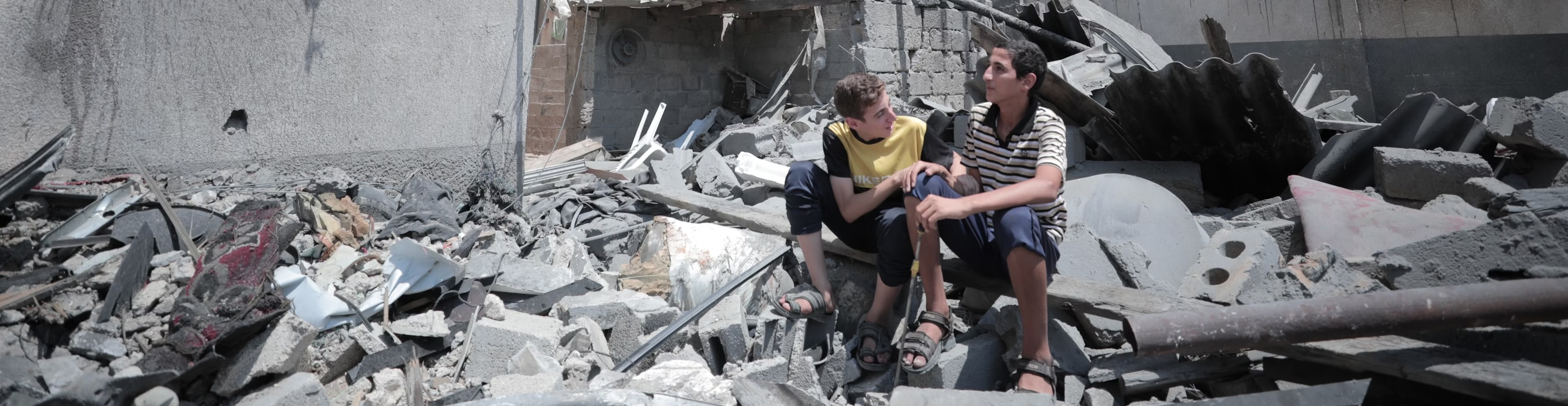 Kids sit in rubble. Credit: Mohammed Ibrahim